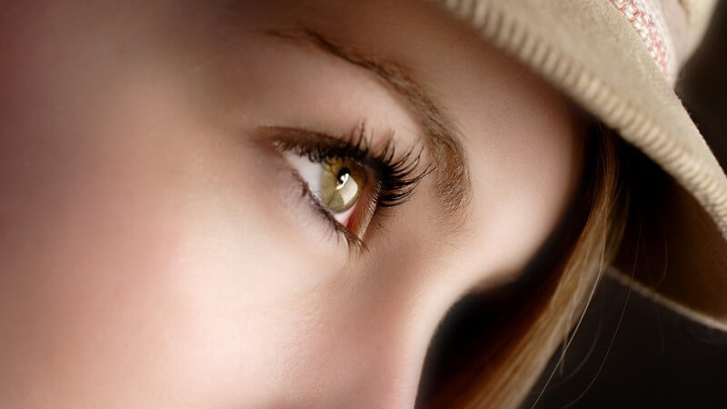Obere Hälfte eines Frauengesichts, rechtes Auge, Hut