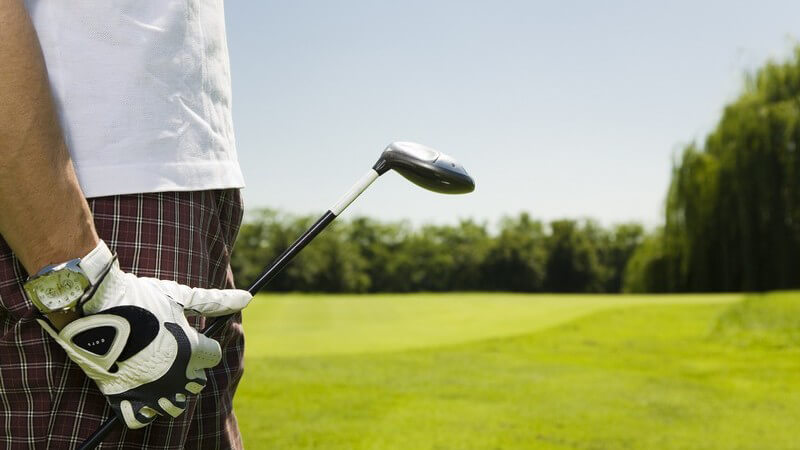 Seitenansicht männlicher Körper mit Golfschläger und Handschuh auf Golfplatz