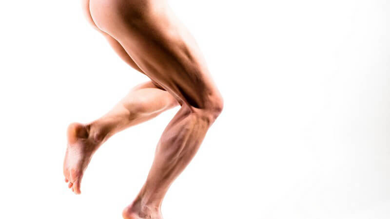 Muskulöse, männliche Beine, das rechte gebeugt stehend, das linke gebeugt nach hinten angehoben