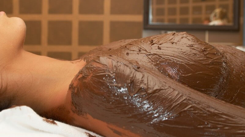 Massage: Oberkörper einer Frau mit Schokolade eingeschmiert