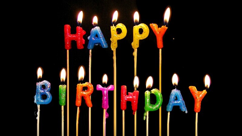 Geburtstagskerzen "Happy Birthday" auf schwarzem Hintergrund