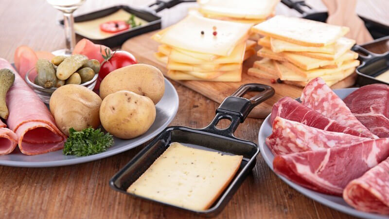 Zutaten für ein Raclette mit Raclettepfannen: Fleisch, Käse, Gemüse
