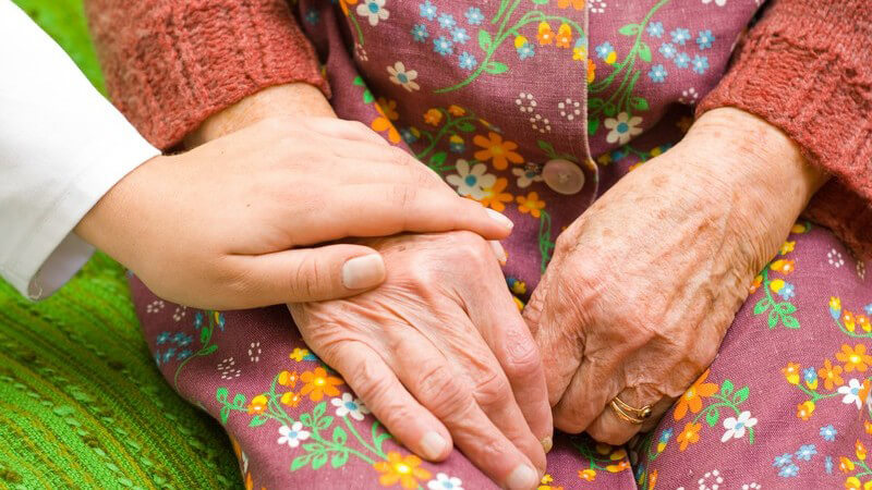 Nahaufnahme Ärztin hält Hände einer alten Frau